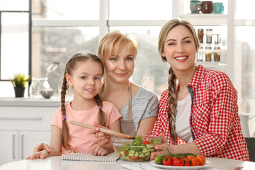 Obraz na płótnie Canvas Young woman with mother and daughter in kitchen