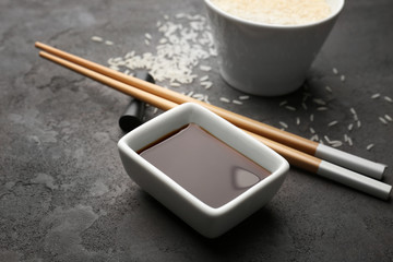 Composition with tasty soy sauce on grey textured background