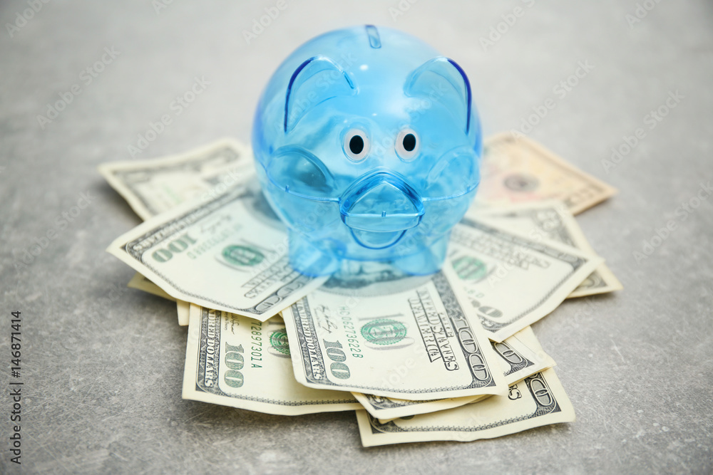 Poster piggy bank and dollar banknotes on table