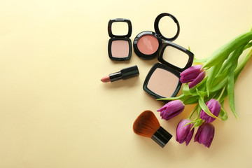 Composition of flowers and cosmetics on yellow table