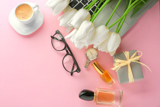 Composition of flowers, cosmetics and accessories on pink table