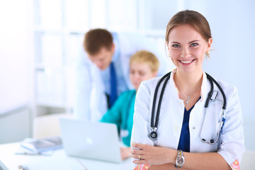 Attractive female doctor in front of medical group
