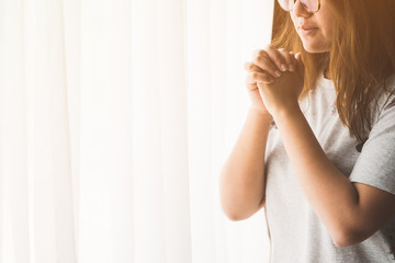 woman praying on the bed in the morning.teenager woman hand praying,Hands folded in prayer on the bed in the morning concept for faith, spirituality and religion