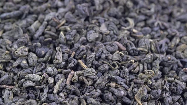 Chinese gunpowder (pearl) green tea - macro turning background
