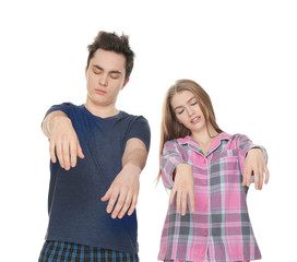 Young sleepy couple suffering from somnambulism on white background