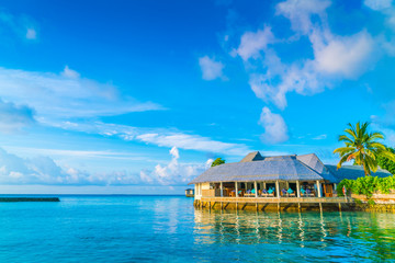 Beautiful water villas in tropical Maldives island at the sunrise time .