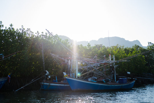 wood fishing boat anchor on sea get ready for trawl. around this place filled nature and mangrove forest background, this image for nature,fishing and boat concept