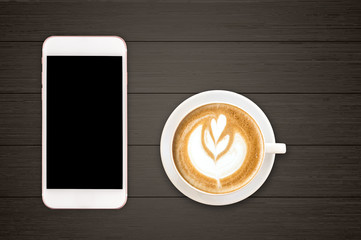 Cup of Latte art coffee with smart phone