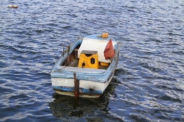 Old weathered wood boat floating on the water in Havana, Cuba