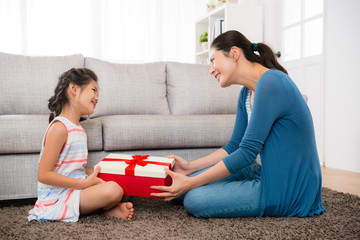 smiling daughter gave her mother a red gift box