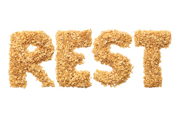 "Rest" written with oat grains word. Shape of oatmeal flakes on isolated white background