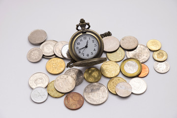 silver pocket watch putting on various sizes coin stack with white background,this image for money saving and retro concept