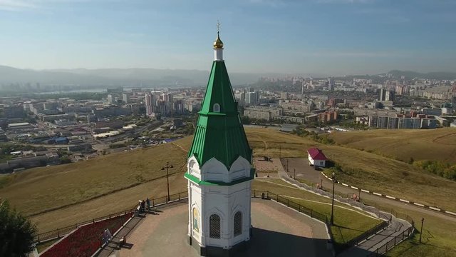Paraskeva pyatnitsa chapel Orhtodox Friday symbol of Krasnoyarsk. Top of Karaulnaya Mountain pagan Tatar temple. Russian old architecture. Observation deck. Aerial drone flight around. Horizon view.