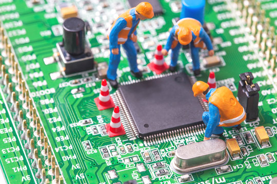 Miniature computer engineers working on a computer microchip