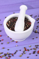 Colorful pepper in white mortar on purple boards