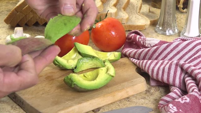 A chef removing the peel from an avocado
