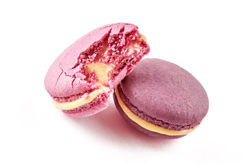 Two colorful French almond cookies macarons or macaroons isolated on white background. One cookie is bitten. Front view.