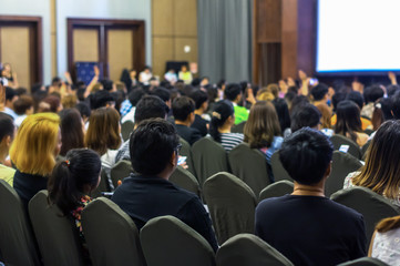 Speaker on the stage with Rear view of Audience in the conference hall or seminar meeting, business and education concept
