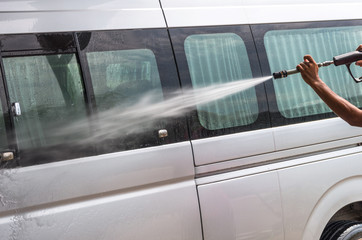 Van Car wash by high pressure cleaners, focus on the car