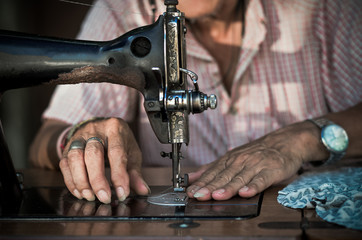 Sewing Process by the vintage sewing machine on old man designer blur background, vintage color tone