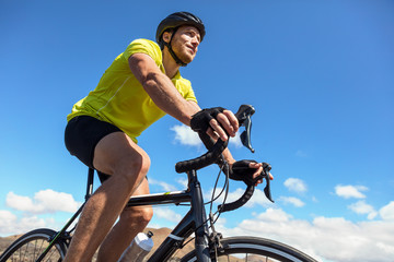 Fototapeta premium Biking tourist man cycling on road bike traveling in summer doing ecotourism. Sports athlete cyclist riding bicycle. Summer holidays.