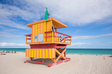 USA, FLORIDA, MIAMI BEACH. APRIL, 2017. Lifeguard tower in a colorful Art Deco style, with blue sky and Atlantic Ocean in the background. World famous travel location. South Beach.