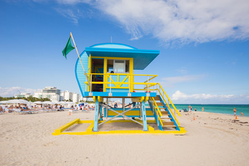 USA, FLORIDA, MIAMI BEACH. APRIL, 2017. Lifeguard tower in a colorful Art Deco style, with blue sky and Atlantic Ocean in the background. World famous travel location. South Beach.