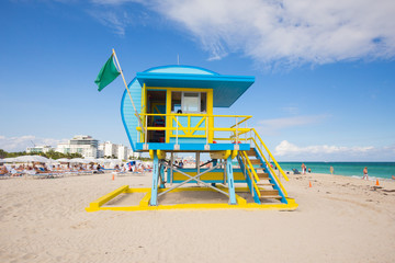 USA, FLORIDA, MIAMI BEACH. APRIL, 2017. Lifeguard tower in a colorful Art Deco style, with blue sky and Atlantic Ocean in the background. World famous travel location. South Beach.