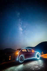 Fototapeta na wymiar Draw a car by flashlight with the milky way background.