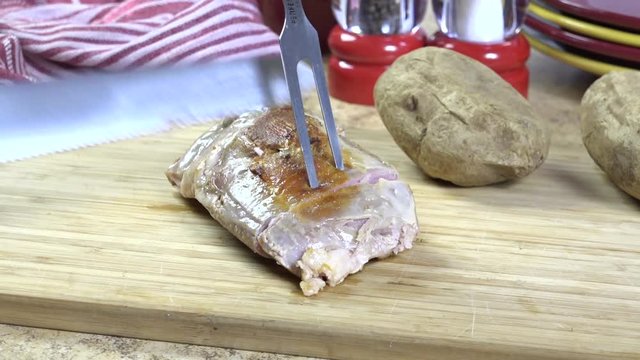 Slicing a pork roast on a cutting board