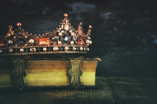 low key image of beautiful queen/king crown on old book