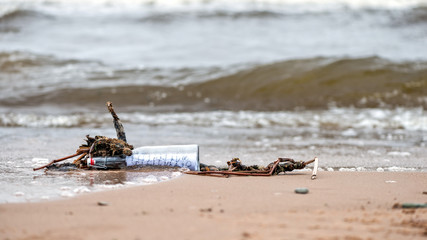 Flushed from the sea old bottle with a message.