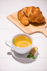 Healthy ginger tea with morning breakfast on a wooden table