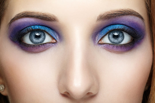 Female face eye with blue and violet makeup