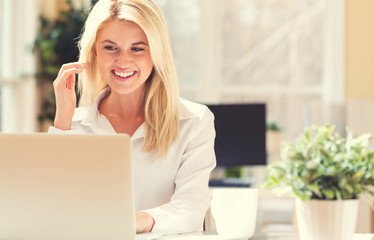 Happy young woman sitting at her desk