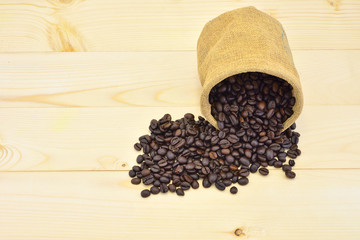 Coffee beans close-up in sack on wood