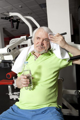 Tired elderly man on a fitness training with bottle of water