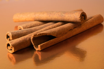 cinnamon sticks on golden glossy background