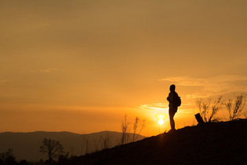 Woman backpacking to watch the sunset.Silhouette
