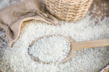 White uncooked rice on wooden surface.