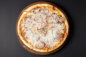 Hot pizza Capricioasa on a rustic wooden table.