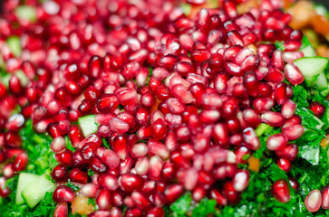 Pomegranate seeds on top of fresh salad