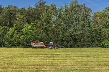 Fototapeta premium Tractor on a field - rural scene in Latvia