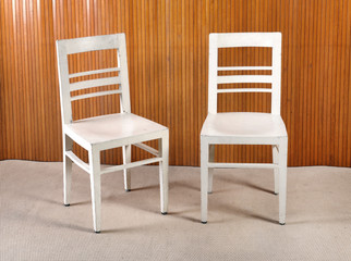 Two plain white painted wooden kitchen chairs