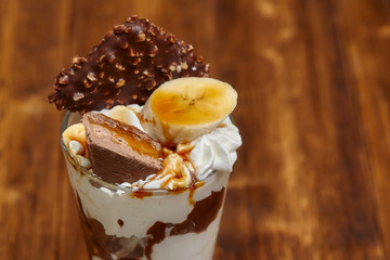Ice cream chocolate cocktail in glass with syrup and banana