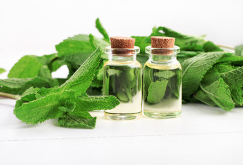 Essential oil of mint with green fresh plant leaves. 
