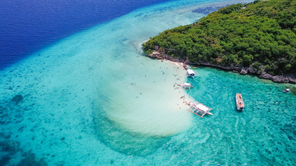 Aerial view of sandy beach with tourists swimming in beautiful clear sea water of the Sumilon...