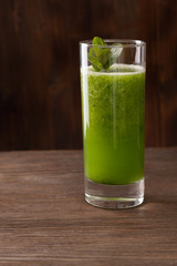 Smoothies green dietary vegetarian on a wooden table with mint leaf