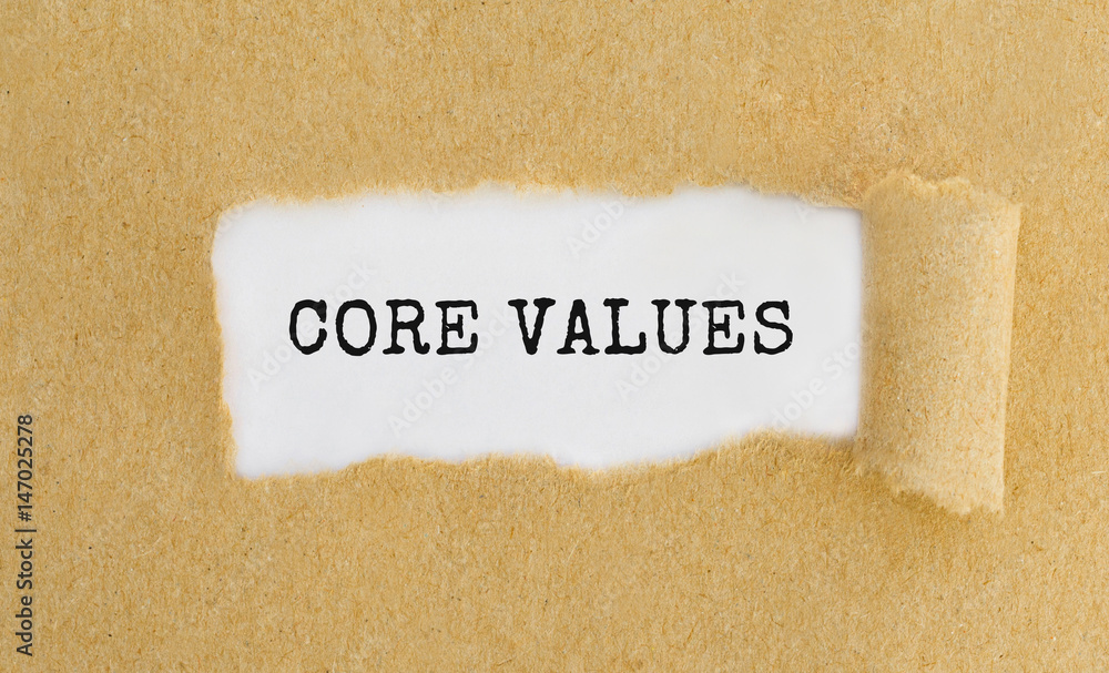 Poster text core values appearing behind ripped brown paper.