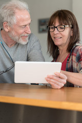 Modern mature couple using tablet